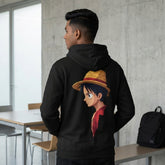 Rear view of a man wearing a black minimalist Luffy hoodie with a high-quality graphic of Monkey D. Luffy on the back, indoor setting.