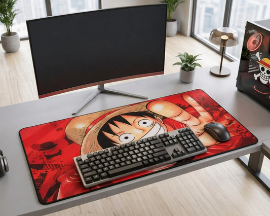 Modern desk setup with large One Piece anime mouse pad featuring Monkey D. Luffy design, keyboard, and monitor in minimalist workspace.
