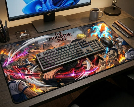 Large One Piece Monster Duo anime desk mat showcasing Zoro and Sanji battle scene artwork on a gaming desk with mechanical keyboard, gaming mouse, and monitor