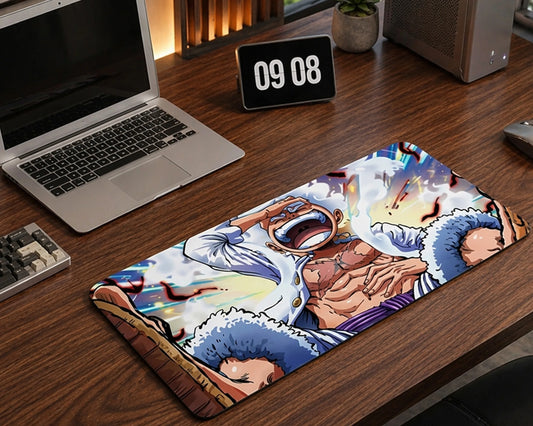 One Piece Gear 5 Luffy anime desk mat on a wooden desk setup with laptop, monitor, and modern workspace accessories.