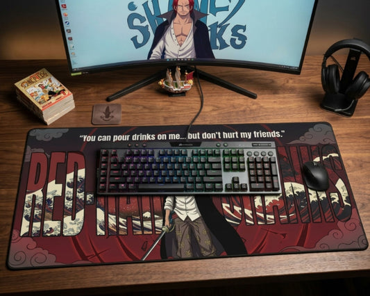 Gaming desk setup with Red Hair Shanks anime mouse pad, RGB keyboard, curved monitor, manga stack, ship figure, mouse, and headset