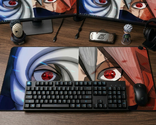Naruto Sharingan themed desk setup with dual monitors, black keyboard, large anime mouse pad, character figures, headset, and mouse.