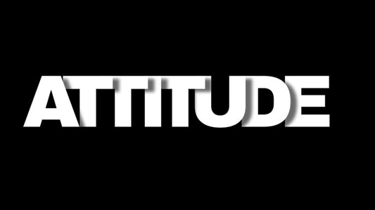 Close-up of bold ‘ATTITUDE’ typography on black desk mat, minimalist motivational design for mindset and confidence.