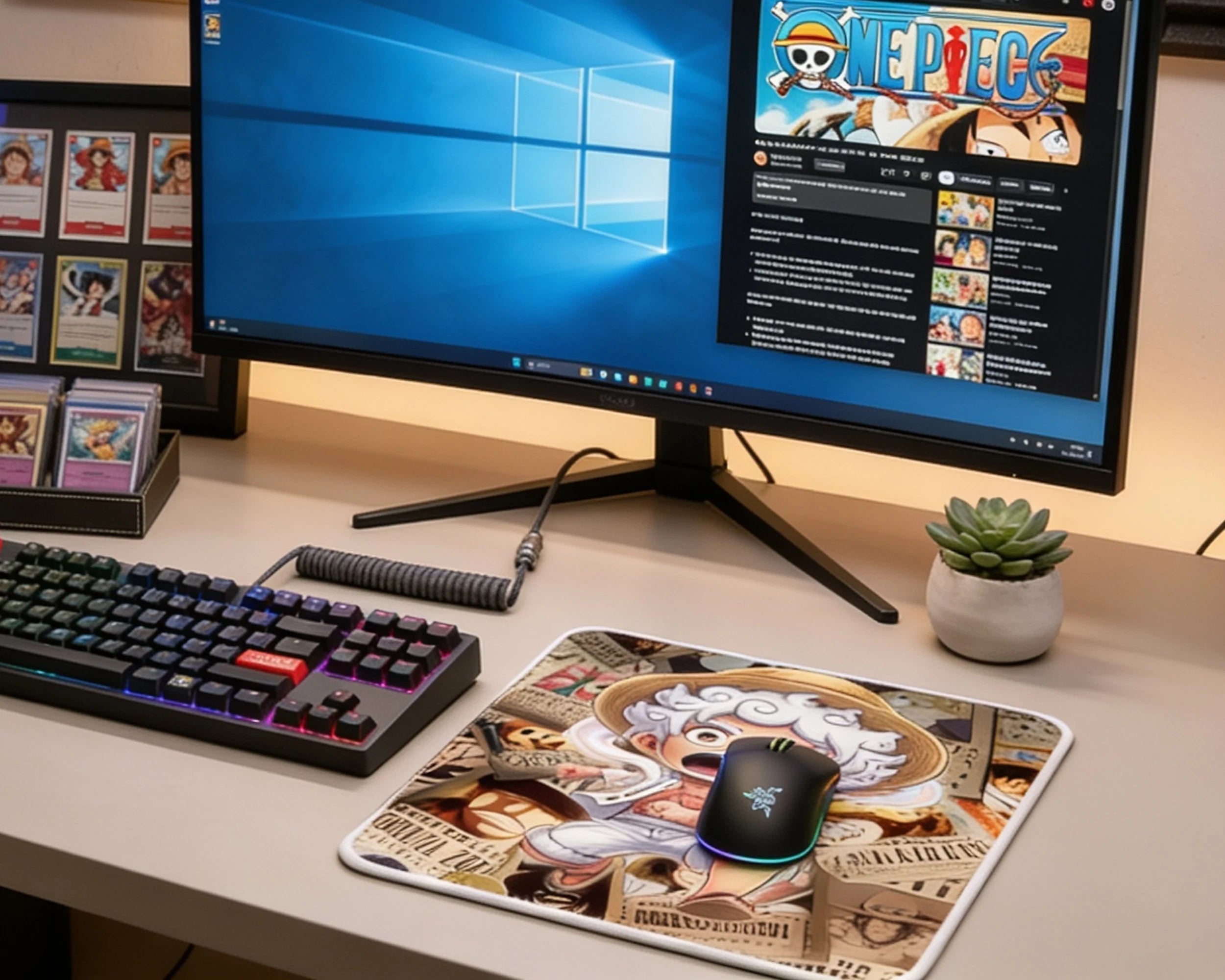 One Piece themed anime mouse pad featuring chibi Gear 5 Luffy character beside RGB keyboard and widescreen monitor