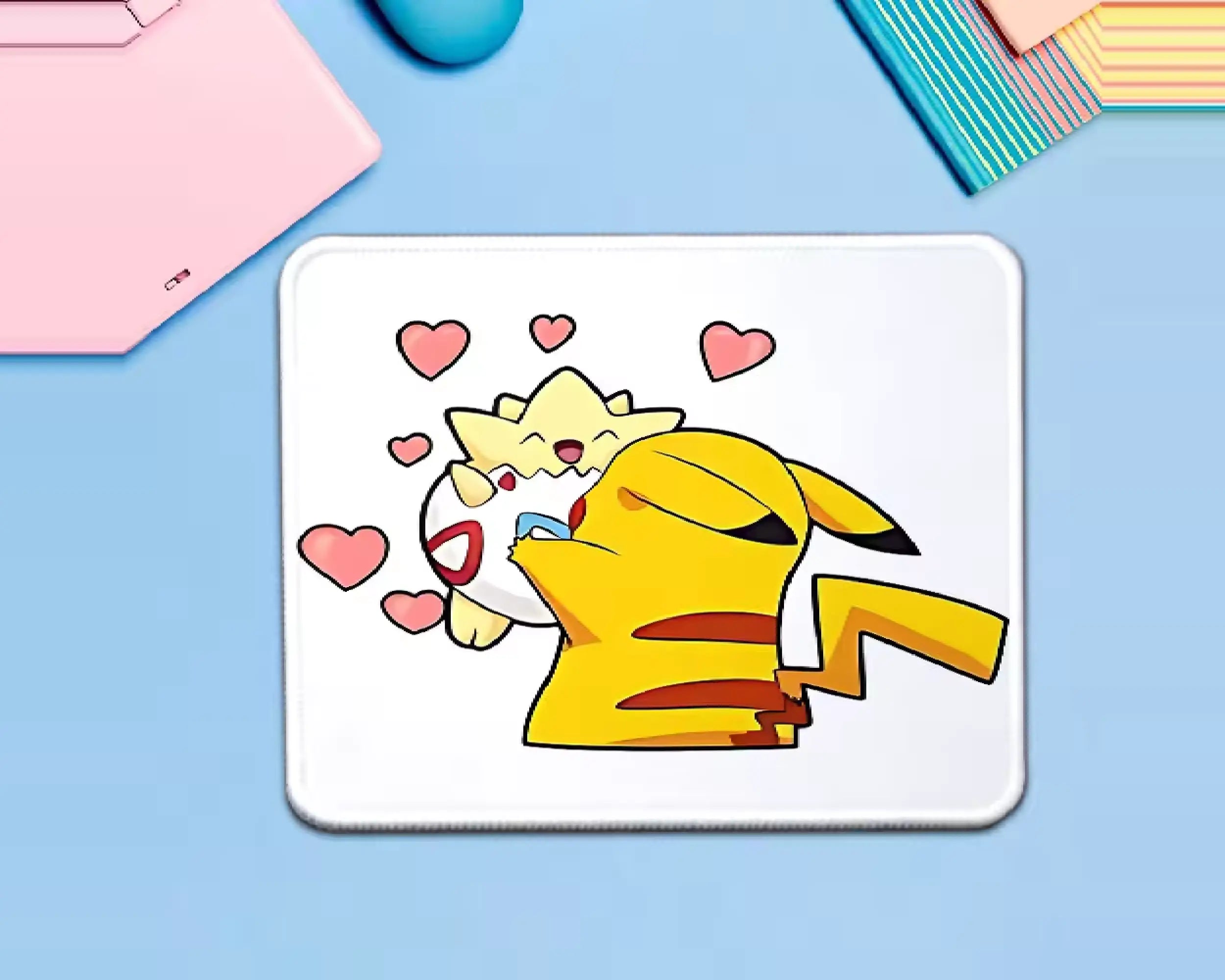 Pikachu cuddling Togepi on a white Pokémon mouse pad, surrounded by pink hearts, with bright yellow character artwork and a cute anime-inspired design.
