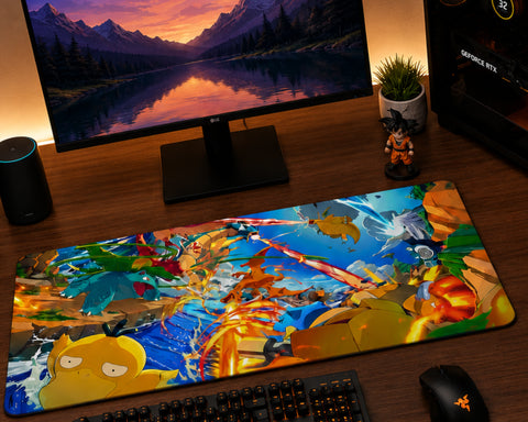 A large rectangular gaming desk mat with a colorful Dragon Ball Z anime battle scene, laid out on a dark wooden desk in front of a computer monitor, keyboard, and mouse.