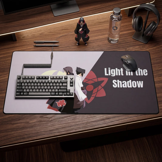 Top-down view of anime desk mat with ‘Light in the Shadow’ text, mechanical keyboard, mouse, headphones, and collectible figure on wooden desk.