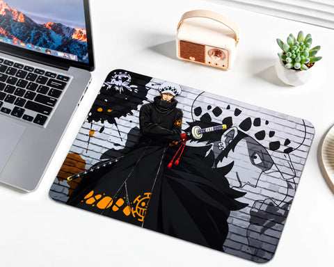 Trafalgar Law One Piece gaming mouse pad featuring his white spotted hat, long black outfit, sword, orange accents, pirate insignia, and monochrome brick wall background.