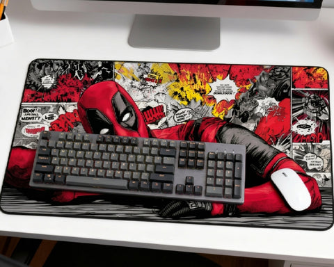 Deadpool comic desk mat setup with gray mechanical keyboard, white mouse, iMac, and red black comic panel artwork on a white desk.