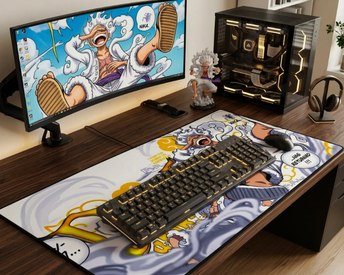One Piece Gear 5 Luffy desk setup with white anime desk mat, curved monitor, custom PC, gold RGB mechanical keyboard, mouse, figure, and headphones.